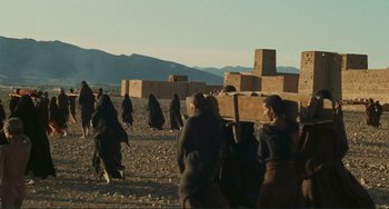 Movie still from “Oedipus Rex” (1967), directed by Pier Paolo Pasolini – A group of people walking across a dirt field; Extreme Wide shot, Low angle