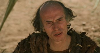 Movie still from “Oedipus Rex” (1967), directed by Pier Paolo Pasolini – An old man with a bald head is looking at the camera; Close Up shot, Low angle