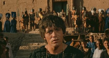 Movie still from “Oedipus Rex” (1967), directed by Pier Paolo Pasolini – A young man in front of a group of statues; Close Up shot, High angle