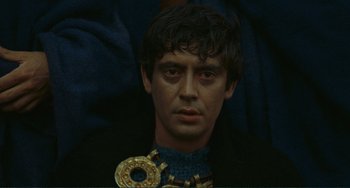 Movie still from “Oedipus Rex” (1967), directed by Pier Paolo Pasolini – A person wearing a necklace; Close Up shot, High angle
