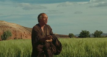 Movie still from “Oedipus Rex” (1967), directed by Pier Paolo Pasolini – An older man in a field with a bag; Medium shot, Low angle