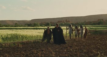 Movie still from “Oedipus Rex” (1967), directed by Pier Paolo Pasolini – A group of people standing in the dirt; Extreme Wide shot, Low angle