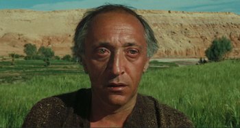 Movie still from “Oedipus Rex” (1967), directed by Pier Paolo Pasolini – A person wearing a brown shirt; Close Up shot, Low angle