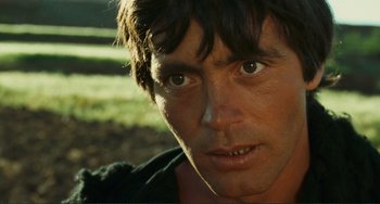 Movie still from “Oedipus Rex” (1967), directed by Pier Paolo Pasolini – A man's face in a grassy area; Close Up shot, Low angle