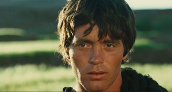 Movie still from “Oedipus Rex” (1967), directed by Pier Paolo Pasolini – A person wearing a black shirt; Close Up shot, Low angle