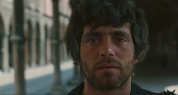 Movie still from “Oedipus Rex” (1967), directed by Pier Paolo Pasolini – A person wearing a black shirt; Close Up shot, Low angle