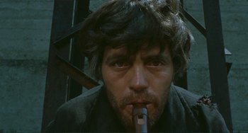 Movie still from “Oedipus Rex” (1967), directed by Pier Paolo Pasolini – A person with a pipe in his mouth; Close Up shot, Low angle