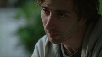 Movie still from “Old Joy” (2006), directed by Kelly Reichardt – A man's face with trees in the background; Close Up shot, Low angle