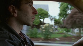 Movie still from “Old Joy” (2006), directed by Kelly Reichardt – A person looking out a car window; Close Up shot, Over the shoulder angle