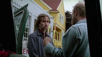 Movie still from “Old Joy” (2006), directed by Kelly Reichardt – Two men standing in front of a yellow house; Close Up shot, Over the shoulder angle