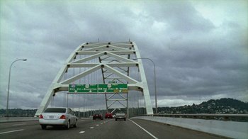 Movie still from “Old Joy” (2006), directed by Kelly Reichardt – Cars driving on a highway under a white bridge; Extreme Wide shot, High angle