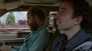 Movie still from “Old Joy” (2006), directed by Kelly Reichardt – Two men sitting in the back seat of a car; Close Up shot, Over the shoulder angle