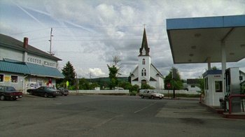 Movie still from “Old Joy” (2006), directed by Kelly Reichardt – A church with a steeple in the middle of a parking lot; Extreme Wide shot, High angle