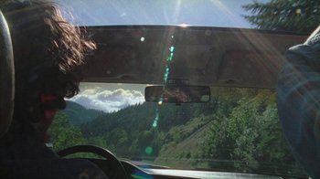 Movie still from “Old Joy” (2006), directed by Kelly Reichardt – A view from a car of a mountain range; Medium shot, High angle