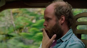 Movie still from “Old Joy” (2006), directed by Kelly Reichardt – A man smoking a cigarette while sitting in a car; Close Up shot, Over the shoulder angle
