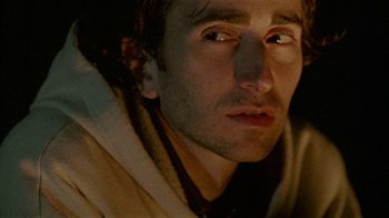 Movie still from “Old Joy” (2006), directed by Kelly Reichardt – A man's face in a dark room; Close Up shot, Low angle