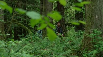 Movie still from “Old Joy” (2006), directed by Kelly Reichardt – A man sitting in the middle of a forest; Wide shot, Over the shoulder angle