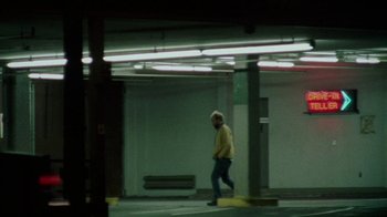 Movie still from “Old Joy” (2006), directed by Kelly Reichardt – A man walking in a parking lot near a building; Wide shot, Over the shoulder angle