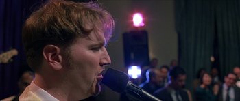 Movie still from “Old School” (2003), directed by Todd Phillips – A man is singing into a microphone in front of an audience; Close Up shot, Low angle