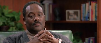 Movie still from “Old School” (2003), directed by Todd Phillips – A person sitting in a chair with his hands crossed; Close Up shot, Low angle