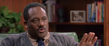 Movie still from “Old School” (2003), directed by Todd Phillips – A man sitting in a chair in a room; Close Up shot, Over the shoulder angle