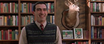 Movie still from “Old School” (2003), directed by Todd Phillips – A man in a sweater vest standing in front of a bookcase; Medium shot, Low angle