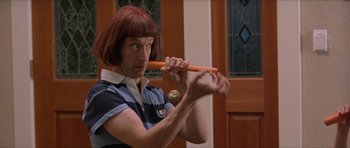 Movie still from “Old School” (2003), directed by Todd Phillips – A woman holding a wooden stick in her hand; Close Up shot, Over the shoulder angle