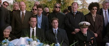 Movie still from “Old School” (2003), directed by Todd Phillips – A group of men in suits and ties standing next to each other in front of flowers; Medium shot, Over the shoulder angle