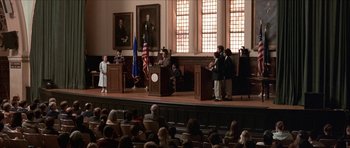 Movie still from “Old School” (2003), directed by Todd Phillips – A group of people standing in front of a podium on a stage; Wide shot, High angle