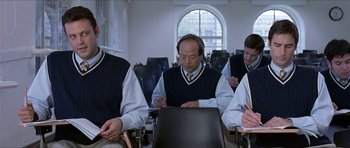 Movie still from “Old School” (2003), directed by Todd Phillips – A group of men sitting at a desk in front of a window; Medium shot, Over the shoulder angle