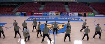 Movie still from “Old School” (2003), directed by Todd Phillips – A group of men standing on top of a basketball court; Wide shot, High angle