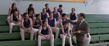 Movie still from “Old School” (2003), directed by Todd Phillips – A group of men sitting on top of a bench in a gym; Wide shot, Over the shoulder angle