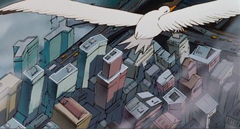 Movie still from “Oliver & Company” (1988), directed by George Scribner – An aerial view of a city with a bird flying over it; Extreme Wide shot, Low angle