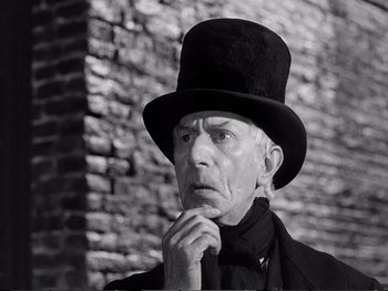 Movie still from “Oliver Twist” (1948), directed by David Lean – An old man wearing a top hat and a black suit; Close Up shot, Low angle