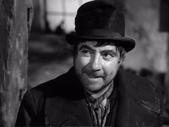 Movie still from “Oliver Twist” (1948), directed by David Lean – A man wearing a top hat and a coat; Close Up shot, Over the shoulder angle