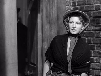 Movie still from “Oliver Twist” (1948), directed by David Lean – An old photo of a woman wearing a hat; Medium shot, Low angle