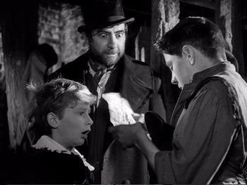 Movie still from “Oliver Twist” (1948), directed by David Lean – A group of people that are looking at a piece of paper; Medium shot, Over the shoulder angle