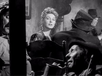 Movie still from “Oliver Twist” (1948), directed by David Lean – An old black and white photo of a woman and a man in front of a mirror; Medium shot, Over the shoulder angle