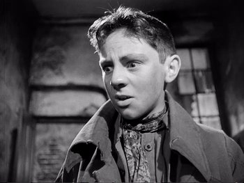 Movie still from “Oliver Twist” (1948), directed by David Lean – A black and white photo of a young man; Close Up shot, Low angle