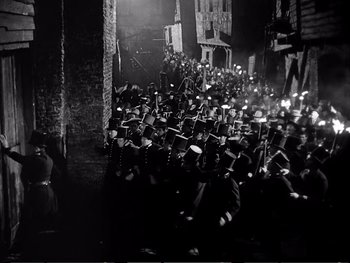 Movie still from “Oliver Twist” (1948), directed by David Lean – A black and white photo of a crowd of men in uniforms; Extreme Wide shot, High angle
