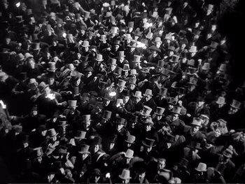 Movie still from “Oliver Twist” (1948), directed by David Lean – A large group of people wearing top hats; Extreme Wide shot, High angle