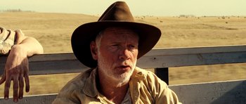 Movie still from “On the Road” (2012), directed by Walter Salles – An older man wearing a brown hat sitting on top of a wooden bench; Close Up shot, Over the shoulder angle