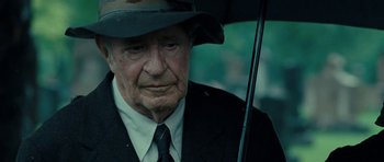 Movie still from “On the Road” (2012), directed by Walter Salles – An old man in a suit and hat holding an umbrella; Close Up shot, Over the shoulder angle