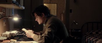 Movie still from “On the Road” (2012), directed by Walter Salles – A man sitting at a table looking down at his cell phone; Medium shot, High angle