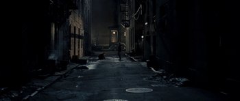 Movie still from “On the Road” (2012), directed by Walter Salles – A person walking down a street with a cat; Extreme Wide shot, High angle