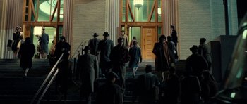 Movie still from “On the Road” (2012), directed by Walter Salles – A group of people walking down the steps of a building at night; Extreme Wide shot, Low angle