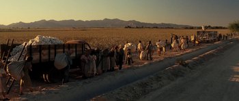 Movie still from “On the Road” (2012), directed by Walter Salles – A group of people standing next to each other near a field; Extreme Wide shot, High angle
