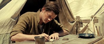 Movie still from “On the Road” (2012), directed by Walter Salles – A man writing on a piece of paper on top of a table; Close Up shot, High angle