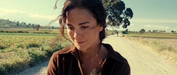 Movie still from “On the Road” (2012), directed by Walter Salles – A person wearing a brown shirt near a dirt road; Close Up shot, High angle
