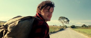Movie still from “On the Road” (2012), directed by Walter Salles – A man with a backpack walking down a dirt road; Close Up shot, Low angle